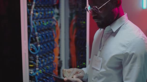 Veri Merkezinde Sunucuya Bakarken Afrikalı Amerikalı Erkek Teknisyenin Tablet Kullanırken — Stok video