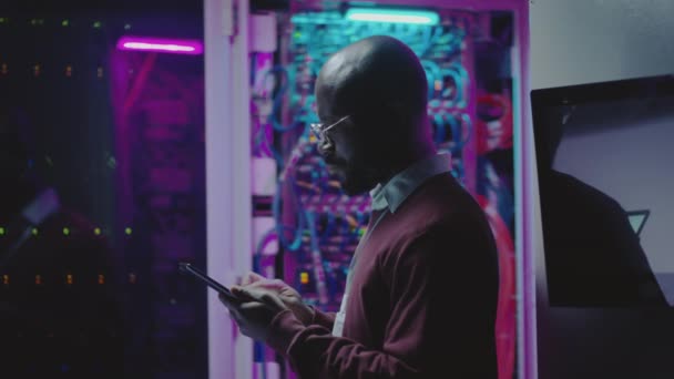 Veri Merkezinin Sunucu Odasında Dijital Tablet Üzerinde Çalışan Afro Amerikan — Stok video
