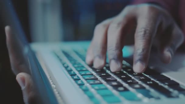 Zbliżenie Afroamerykańskiego Programistę Piszącego Laptopie Ciemnej Serwerowni Niebieskim Światłem Neonowym — Wideo stockowe