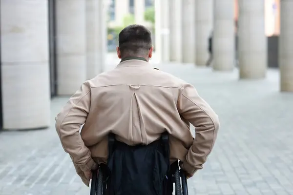 Вид Сзади Молодого Человека Едущего Инвалидной Коляске Вдоль Улицы — стоковое фото
