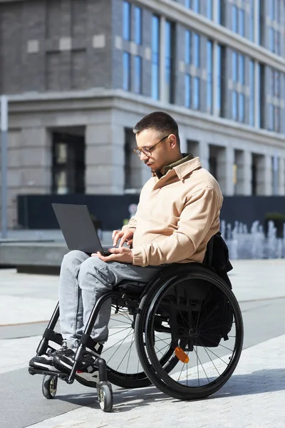 Вертикальное Изображение Молодого Человека Ограниченными Возможностями Работающего Ноутбуке Сидящего Инвалидной — стоковое фото