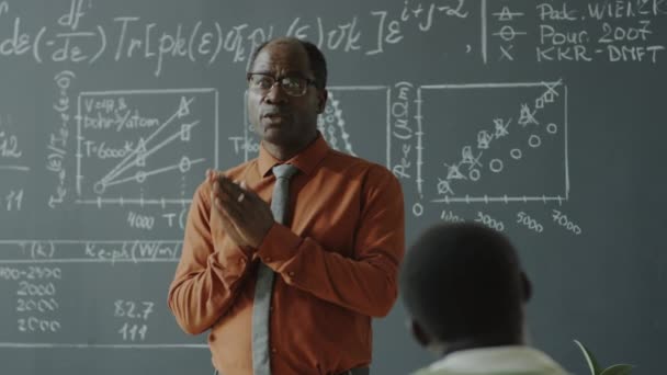 Αφροαμερικανός Καθηγητής Στέκεται Μπροστά Από Τον Πίνακα Μαθηματικούς Τύπους Και — Αρχείο Βίντεο