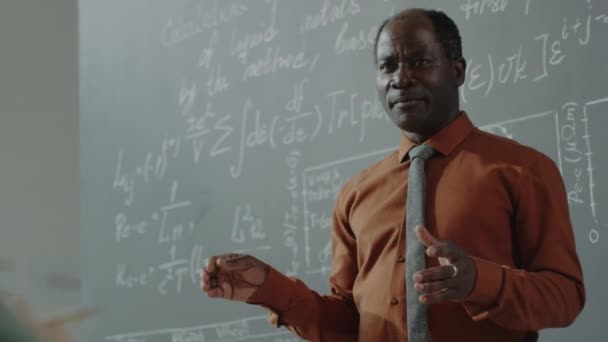 Cintura Hacia Arriba Tiro Profesor Afroamericano Apuntando Pizarra Con Fórmulas — Vídeos de Stock