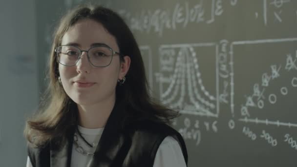 Retrato Estudiante Mujer Caucásica Gafas Posando Para Cámara Junto Pizarra — Vídeos de Stock