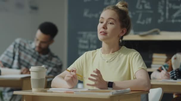 Young Female Student Taking Notes Desk Classroom Raising Arm Asking — Stock Video