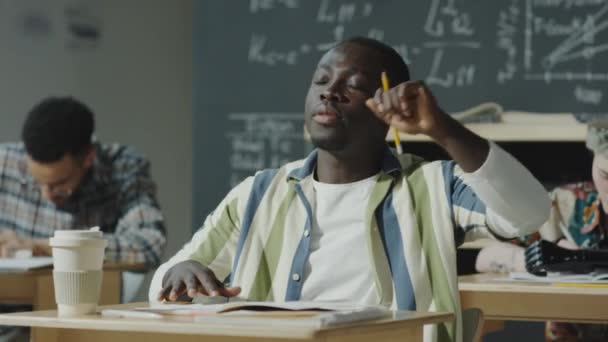 Afrika Kökenli Amerikalı Erkek Öğrenci Masada Oturuyor Kollarını Kaldırıyor Üniversitede — Stok video