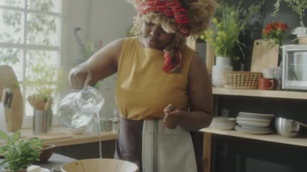 Афроамериканка Фартуке Добавляет Воду Деревянную Миску Время Приготовления Пищи Кухне — стоковое видео