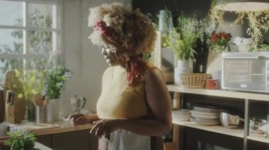 Afro-Amerikalı kadın yemek blogcusu taze dolmalık biber gösteriyor ve mutfakta online aşçılık ustası dersi verirken kamerada konuşuyor.