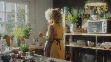 Afro-Amerikan mutfak blogcusu ahşap tahtayı alıyor ve kurutulmuş domatesi bıçakla kesiyor.