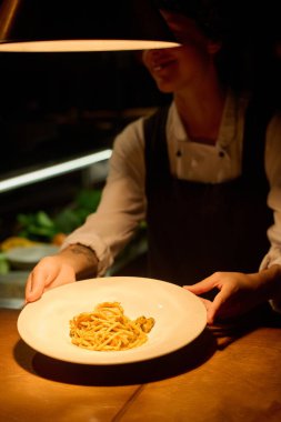 Bistro 'nun misafiri için yapılan iştah açıcı geleneksel İtalyan makarnası ile geçen kafe çalışanının ellerine odaklan.
