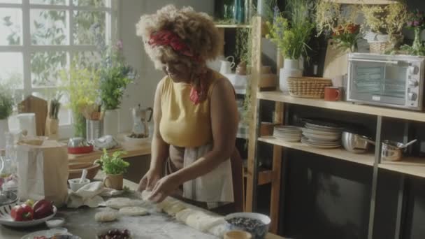 Young African American Woman Flattening Dough Pieces Kitchen Table Speaking — Stock Video
