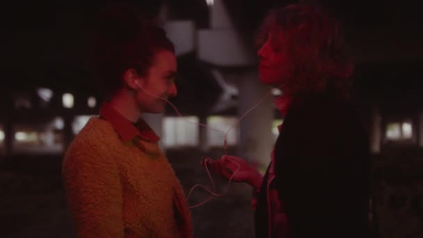 Genç Bayan Arkadaşın Kulaklıklarını Paylaşırken Şehir Köprüsü Altında Kırmızı Işıkta — Stok video