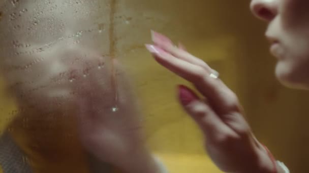 手でぬれた鏡を拭く若い女性のショットを閉じると彼女の反射で部屋にネオンライト — ストック動画