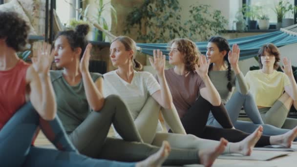Grupa Kobiet Ćwiczących Siedzącą Pozycję Twist Podczas Zajęć Jogi Instruktorką — Wideo stockowe