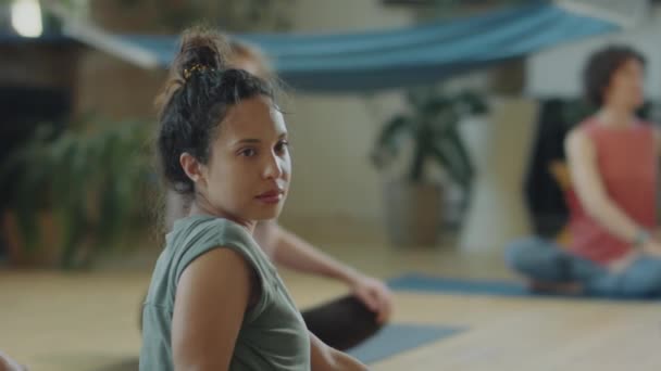 Rack Focus Shot Young Woman Doing Spinal Twist Group Yoga — стоковое видео
