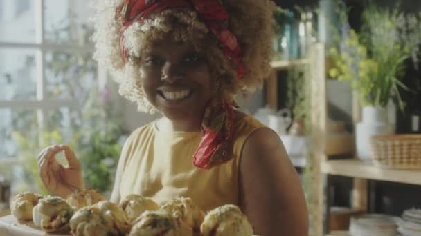 Χαρούμενη Αφρο Αμερικανίδα Που Μυρίζει Φρεσκοψημένα Ψωμάκια Χαμογελώντας Και Μιλώντας — Αρχείο Βίντεο