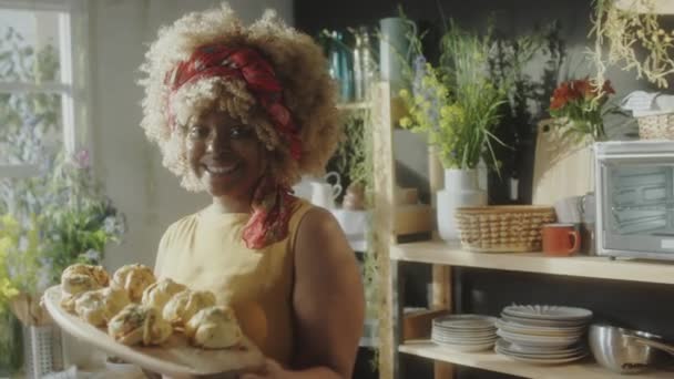 Portret Radosnej Afroamerykanki Trzymającej Drewnianą Deskę Świeżo Upieczonymi Bułeczkami Domowej — Wideo stockowe