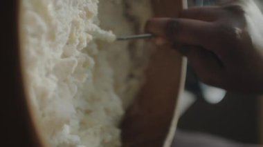 Afro-Amerikalı kadının mutfakta yemek pişirirken hamuru tahta kasede yoğuruşunun dikey çekimi.