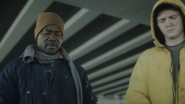 在废弃的建筑里 一个成熟的黑人流浪汉和他的高加索朋友把手放在火桶上取暖 — 图库视频影像