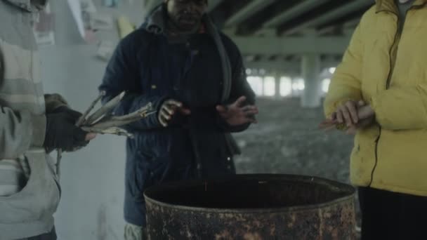 Obdachloser Wirft Trockene Holzstäbe Tonne Während Mit Freunden Feuer Verlassenem — Stockvideo