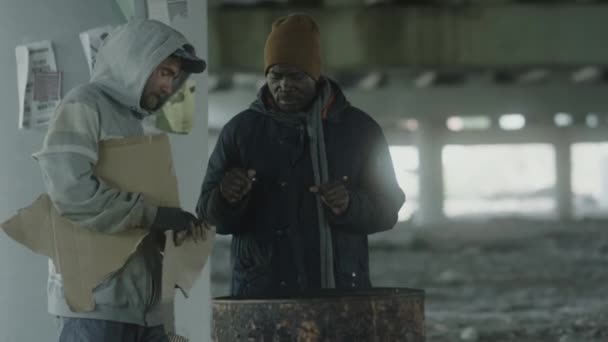 노숙자 버려진 건물에서 난방을 밝히고 아프리카 미국인 친구가 있습니다 — 비디오