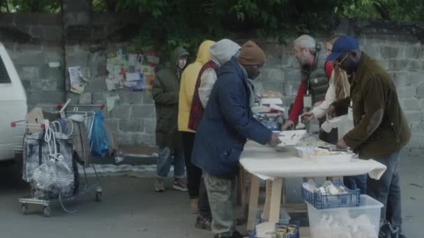 Багатоетнічні Волонтери Які Обслуговують Безкоштовне Харчування Бездомних Вулиці — стокове відео