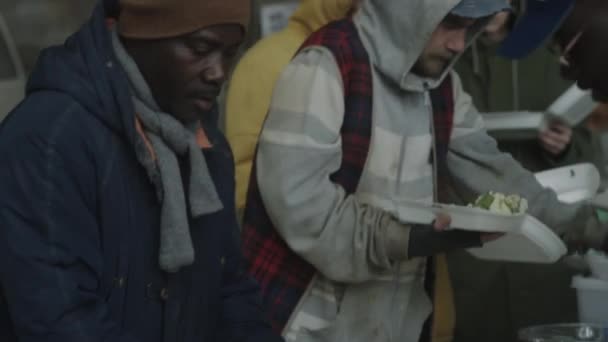 Homeless People Receiving Free Food Served Volunteers Outdoor Soup Kitchen — Stock Video