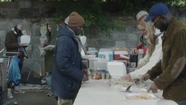 Groep Vrijwilligers Serveert Gratis Voedsel Voor Daklozen Tijdens Het Werken — Stockvideo
