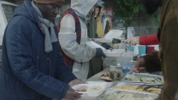 Skupina Bezdomovců Dostává Jídlo Zdarma Dobrovolníků Venkovní Polévkové Kuchyně — Stock video