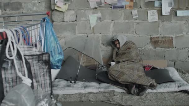 Evsiz Bir Adam Sokakta Paçavralar Içinde Uzanmış Elinde Bardak Tutarak — Stok video
