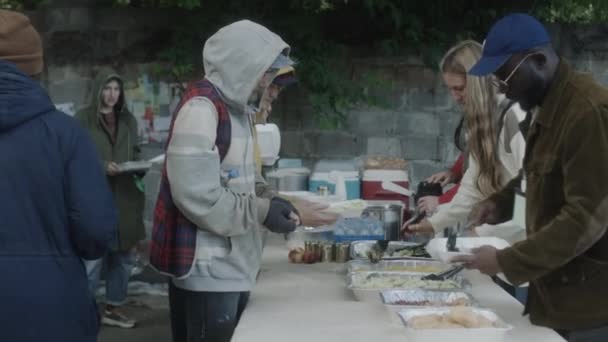 Voluntarios Multiétnicos Sirviendo Comida Gratis Para Vagabundos Comedor Calle Ciudad — Vídeo de stock