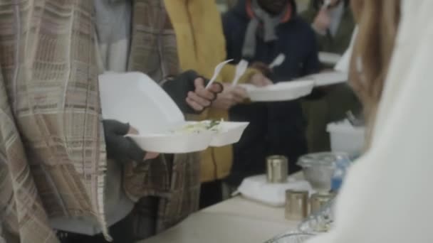 Grupp Multietniska Hemlösa Som Håller Plastbehållare Som Volontär Som Serverar — Stockvideo