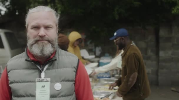 Retrato Voluntário Sênior Com Barba Cinza Crachá Posando Para Câmera — Vídeo de Stock