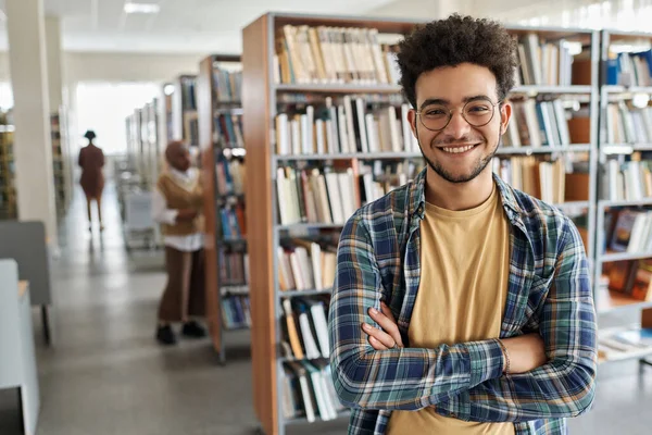 大学生站在高校图书馆时戴眼镜对着相机微笑的画像 — 图库照片