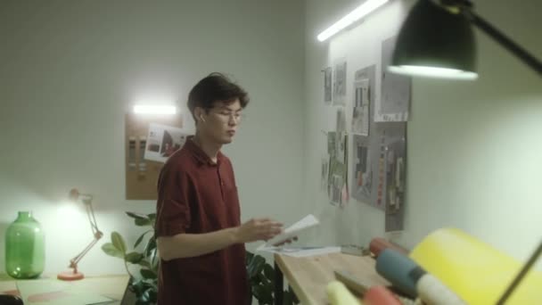 Gen Asiatischer Innenarchitekt Heftet Gedruckte Bilder Die Wand Während Büroarbeitsplatz — Stockvideo