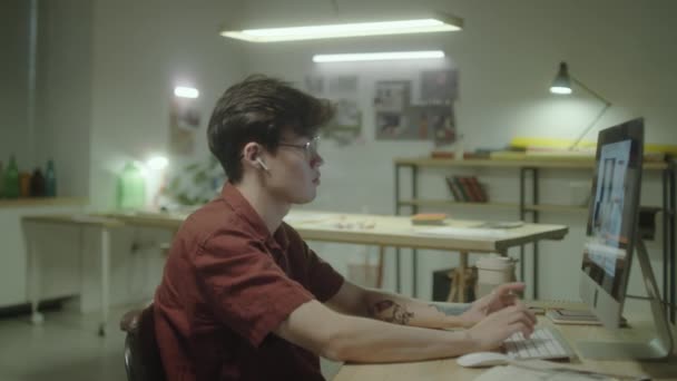 在无线耳机领域工作的年轻的亚洲设计师在计算机上做内部计划 并在深夜做笔记 — 图库视频影像