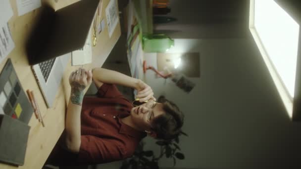Vertikální Záběr Mladého Asijského Designéra Sedícího Stolem Laptopem Mluvícího Mobilním — Stock video