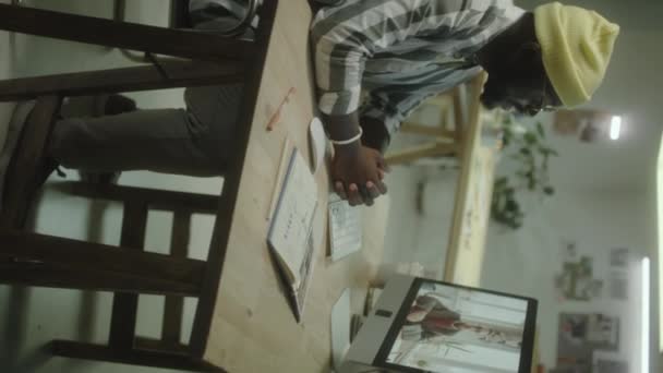 非洲裔美国人设计师坐在创意工作室的办公桌前 在夜间工作时通过计算机视频电话与同事交谈的垂直照片 — 图库视频影像