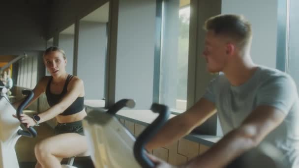 Young Man Woman Sportswear Cycling Exercise Bikes Speaking While Training — Stock Video