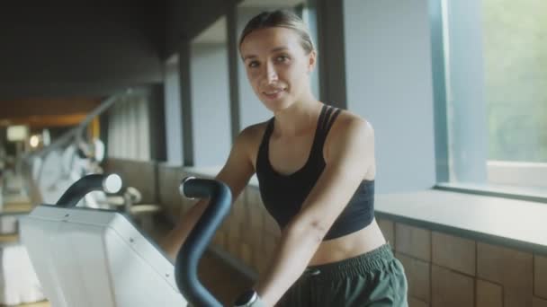 Портрет Привлекательной Женщины Спортивной Одежде Сидящей Велотренажере Спортзале Позирующей Перед — стоковое видео
