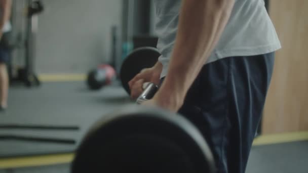 在体育馆锻炼的时候 穿着运动服的强壮男子做杠铃二头肌卷曲的特写镜头 — 图库视频影像