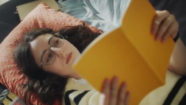 Vista Alto Ângulo Menina Óculos Deitado Sofá Livro Leitura Enquanto — Vídeo de Stock