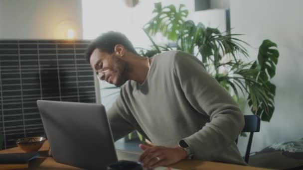 사무실에서 로장식된 책상에서 일하는 지판으로 노트북을 충전하는 젊은이 — 비디오