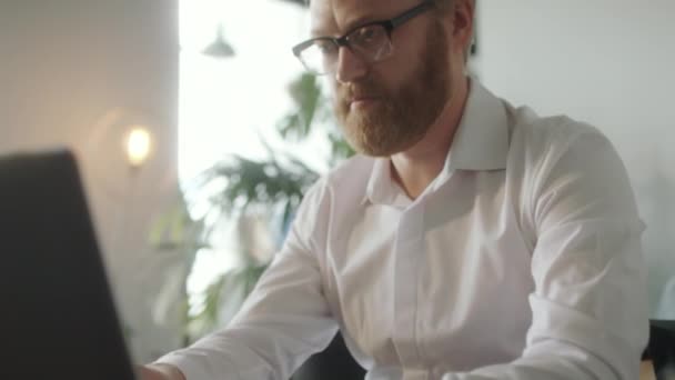 Наклоните Снимок Бородатого Бизнесмена Очках Белой Формальной Рубашке Печатающей Ноутбуке — стоковое видео