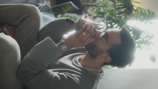 Vertical Shot Young Man Drinking Tea Mug While Sitting Sofa — Stock Video