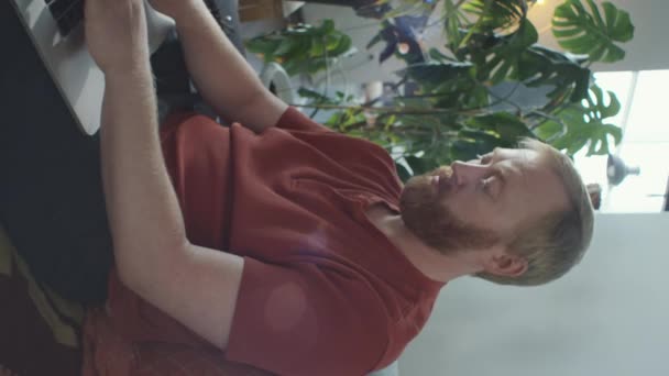 남자의 소파에 컴퓨터로 타이핑 원격으로 작업하는 — 비디오