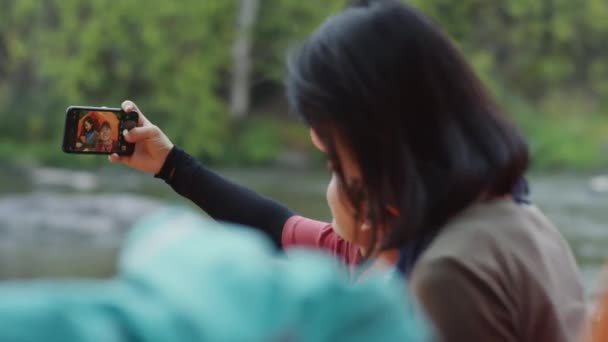 Nehir Kenarında Kamp Yaparken Cep Telefonuyla Selfie Çeken Iki Kadın — Stok video
