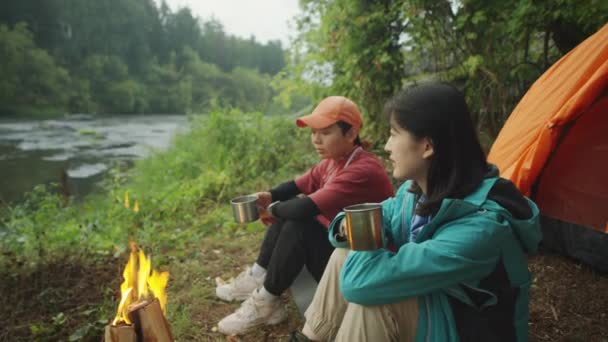 Duas Turistas Asiáticas Sentadas Lado Fogueira Com Canecas Chá Falando — Vídeo de Stock