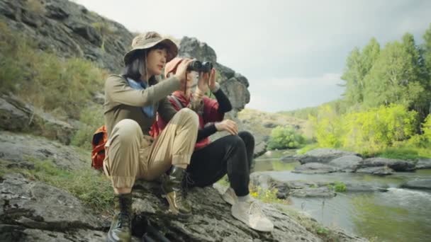 Μέτριο Μακρινό Πλάνο Δύο Ασιάτισσες Τουρίστριες Που Κάθονται Στην Όχθη — Αρχείο Βίντεο
