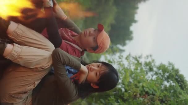 亚洲女同性恋夫妇坐在篝火边喝茶 喝茶的垂直镜头 — 图库视频影像